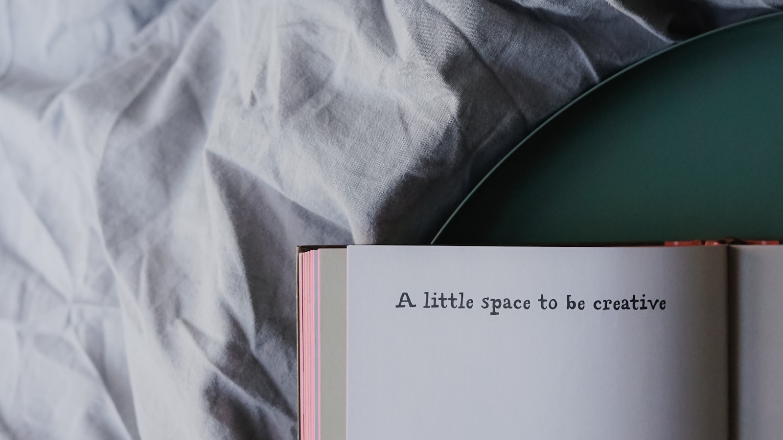 Open notebook on a bed with a short creative message