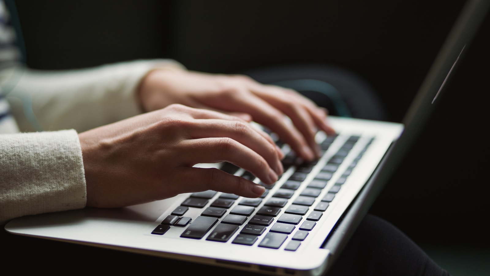 Hands typing on a laptop while researching OneNote alternatives for Linux