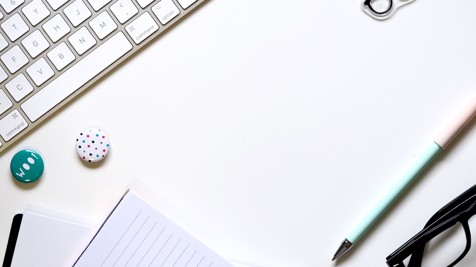 White keyboard and notebook on a bright desk