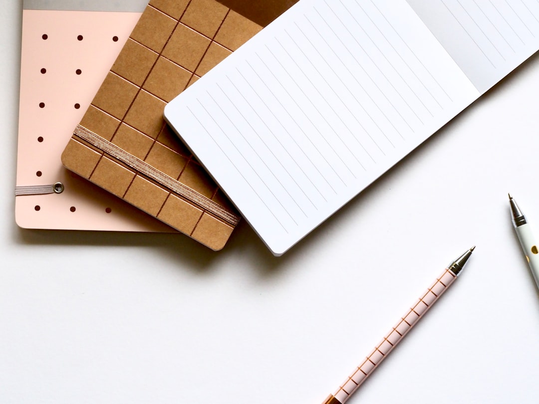 Simple lined notebook beside complex geometric objects on a desk, representing the choice between a structured object model and a lighter writing surface