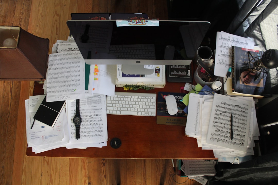 Cluttered desk with many open tabs and notebooks beside one clean notebook, representing the move from a heavy all-in-one workspace to a focused owned system