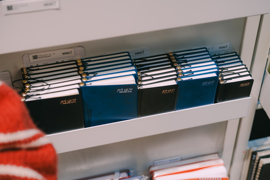 Organized shelf of labeled physical binders and notebooks, representing a productivity system you pay for once and keep on infrastructure you control