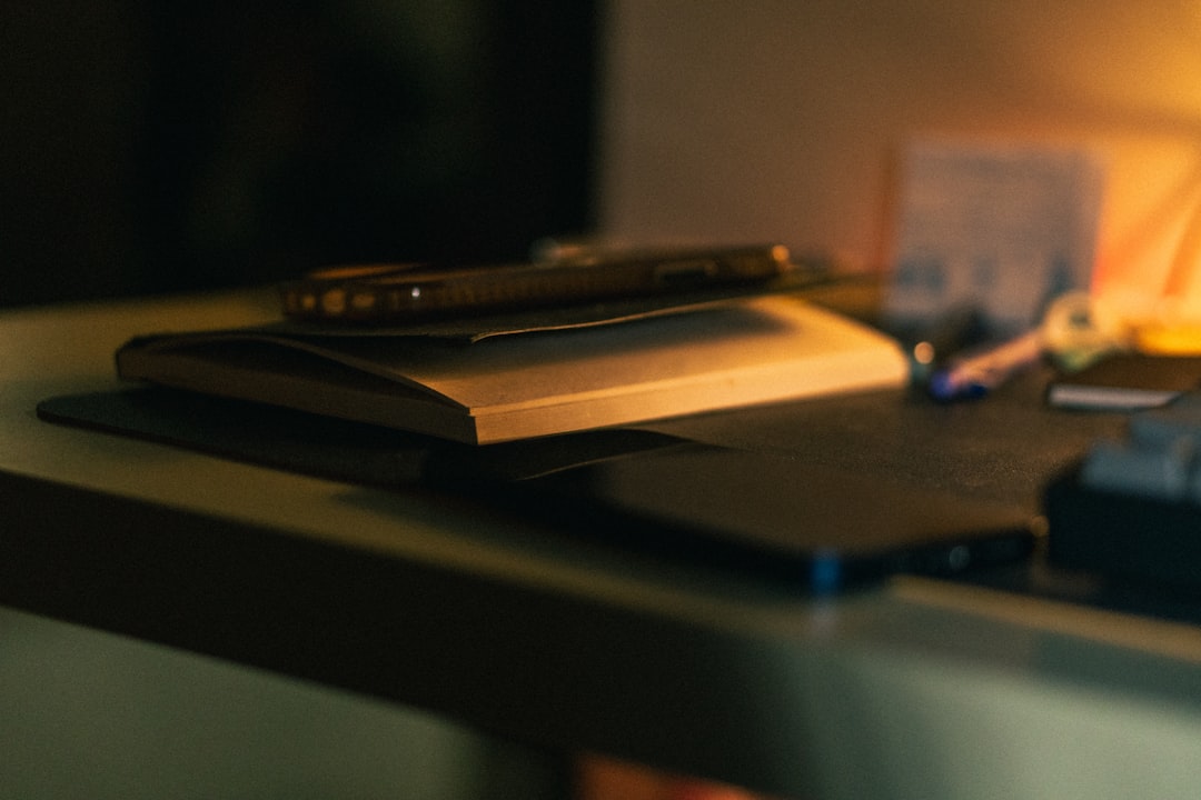 Quiet focused desk with a single open notebook and a pen, representing a calm, low-decision productivity surface that does not demand high executive function