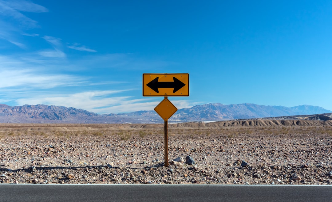 A road sign pointing in two opposite directions in a desert landscape, representing URL redirection during a website migration