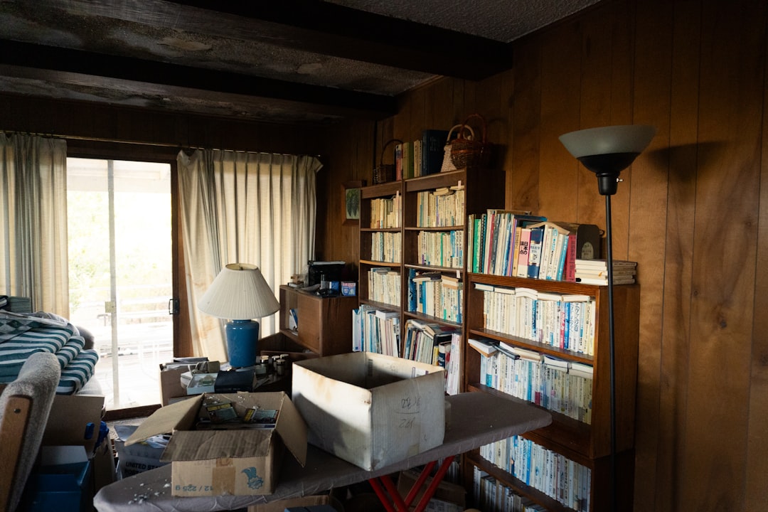A cluttered storage room with bookshelves and packed boxes ready to be cleared out