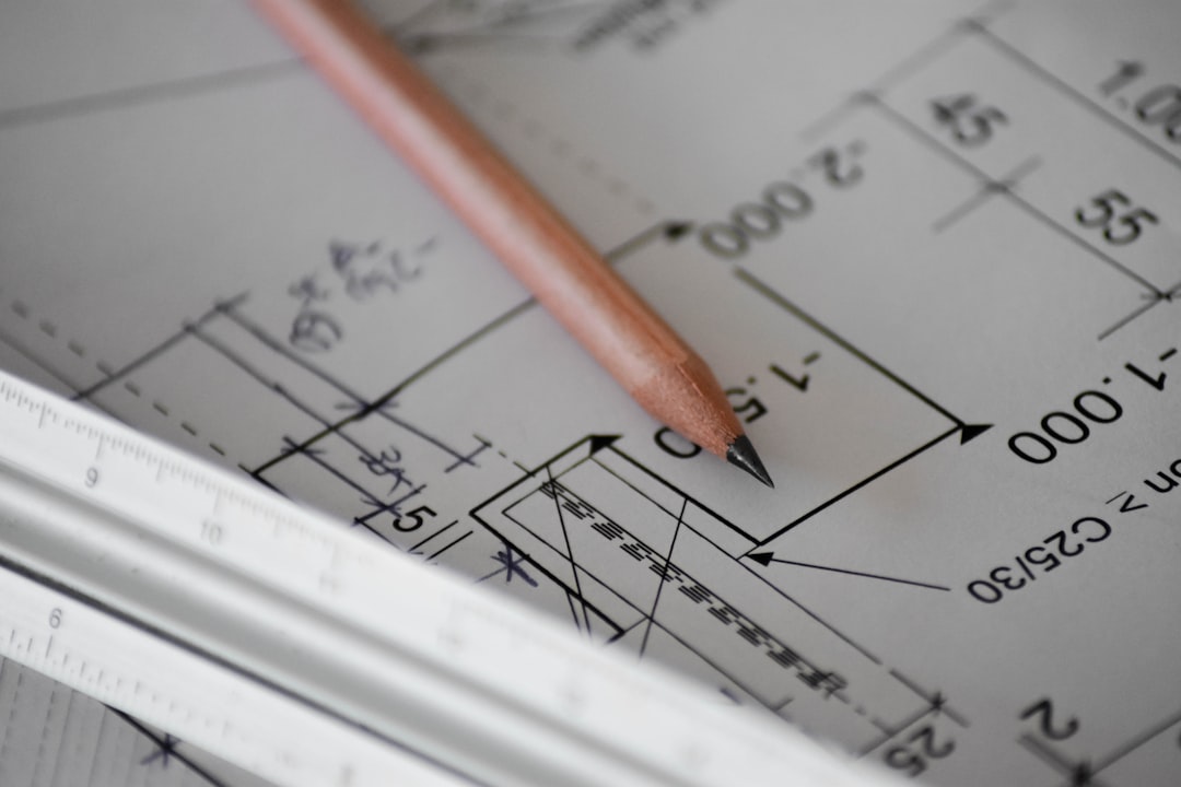 A pencil and ruler resting on a technical blueprint drawing