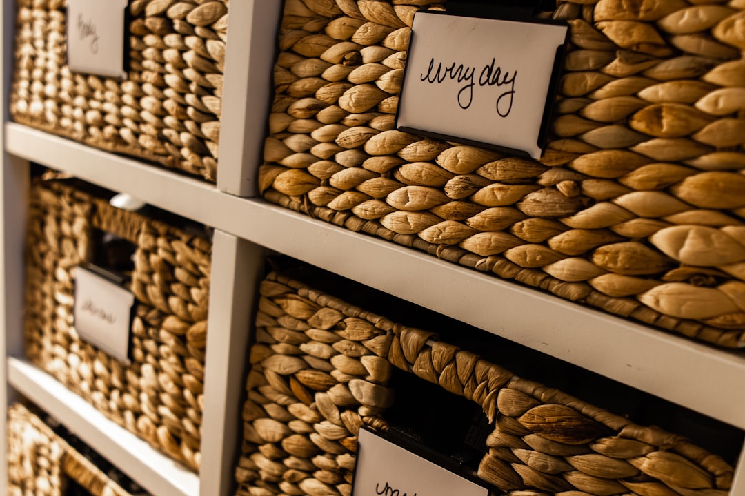 Woven storage baskets on a shelf with handwritten labels reading everyday and other categories