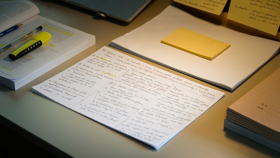 Handwritten study notes spread across a desk alongside pens and sticky notes