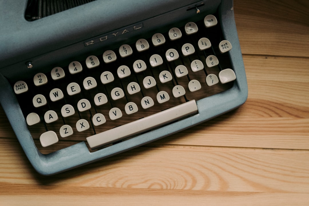 A vintage typewriter with round keys sitting on a wooden table, representing the tactile, considered feel of writing in Bear
