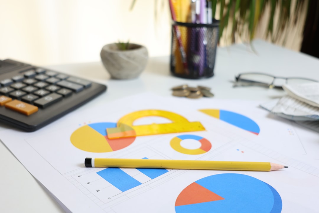 A desk with a calculator, a pencil, and printed pie and bar charts, representing product analytics and the numbers behind a usage bill