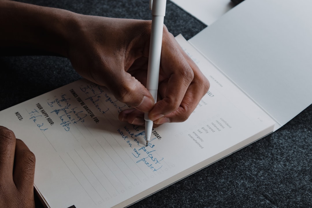 A hand writing short bullet points on a notepad with a pen, representing capturing a decision live rather than reconstructing it afterward