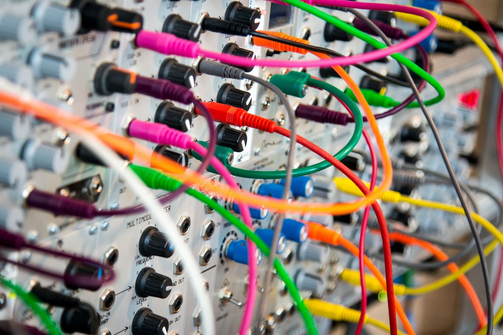 Close-up of colorful patch cables connected across a bank of hardware ports, representing many tools wired into one system