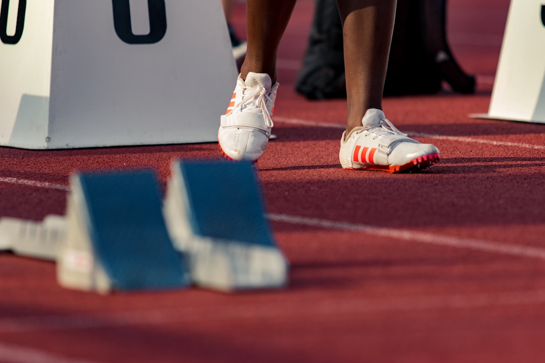 A sprinter's feet in starting blocks on a running track, about to begin a race
