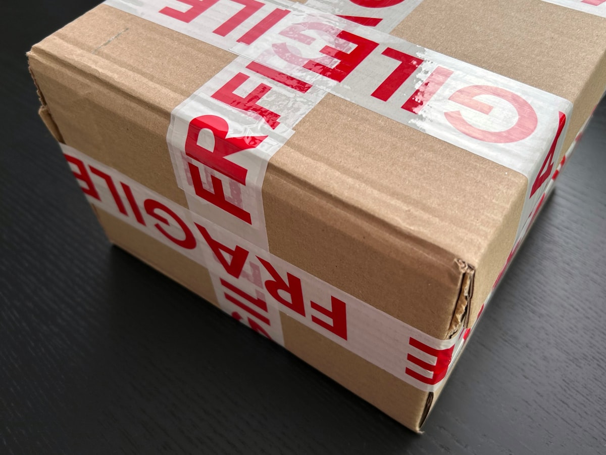A cardboard box sealed with fragile packing tape, representing packing up a workspace to move it elsewhere