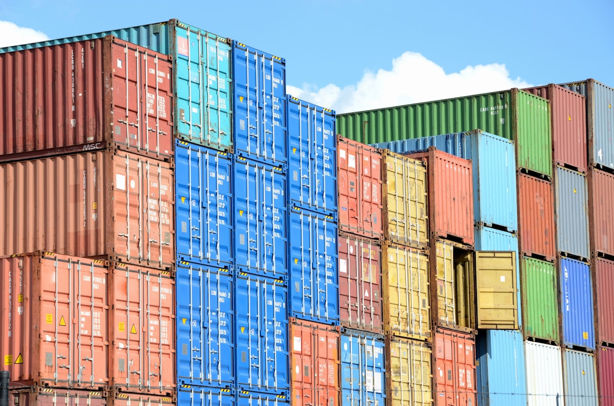 Shipping containers stacked at a port, representing the metered usage that both platforms bill by