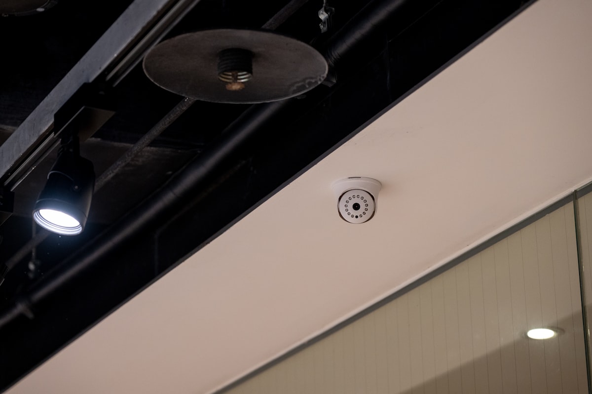 A security camera mounted on a ceiling among exposed pipes, representing a monitoring system that only matters the moment something actually goes wrong