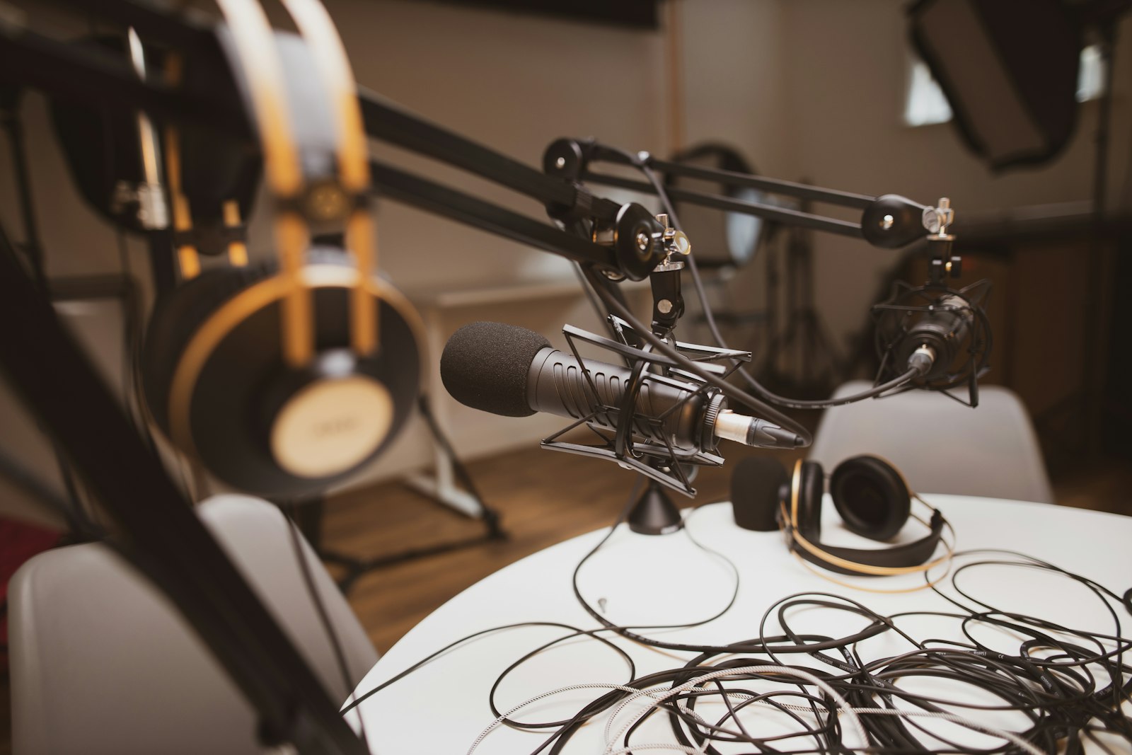 A studio condenser microphone on a boom arm in a quiet recording space