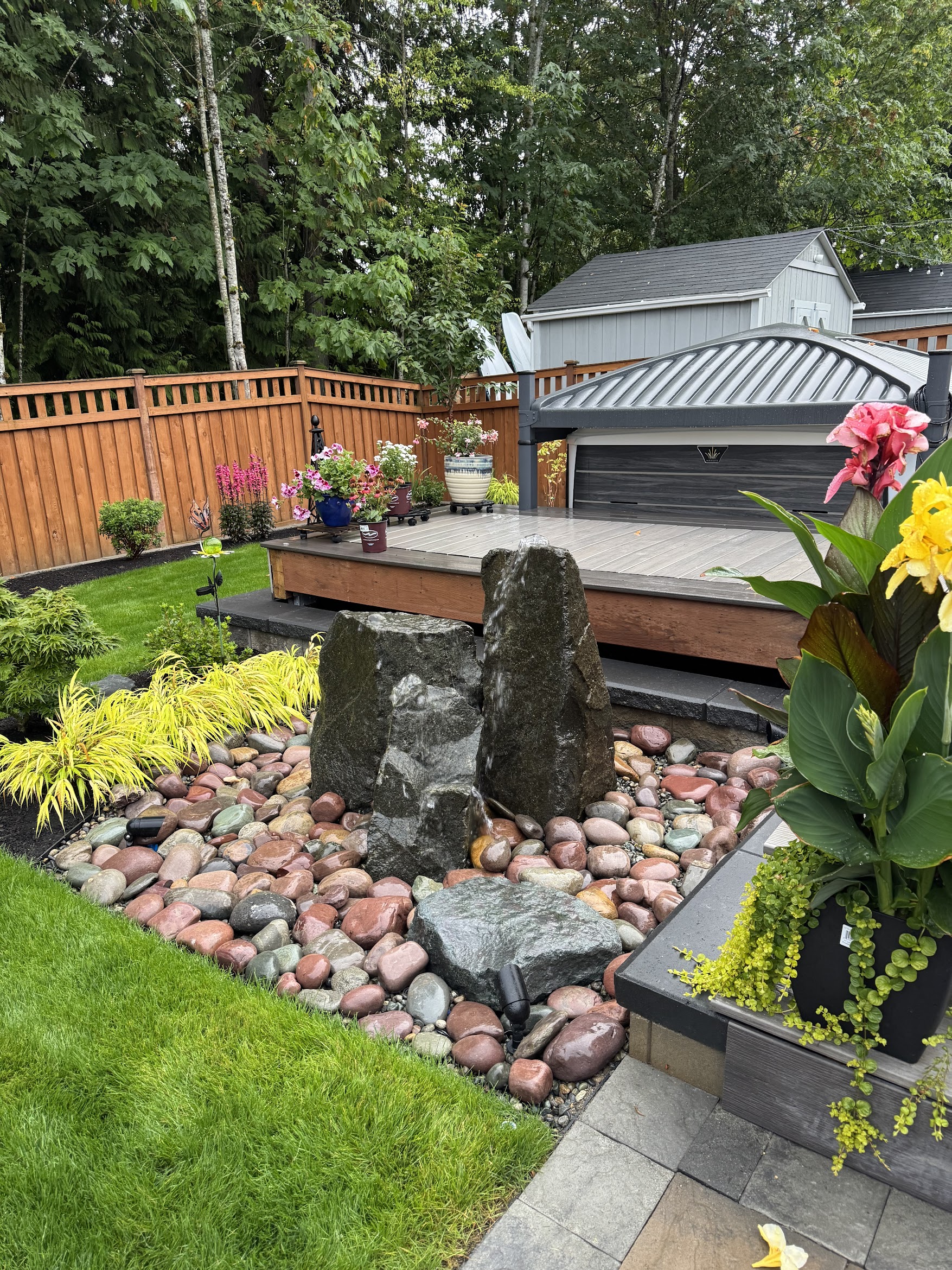 Modern patio with water feature, colorful stones, flowers, and greenery at Todd's Nursery, Puyallup, WA