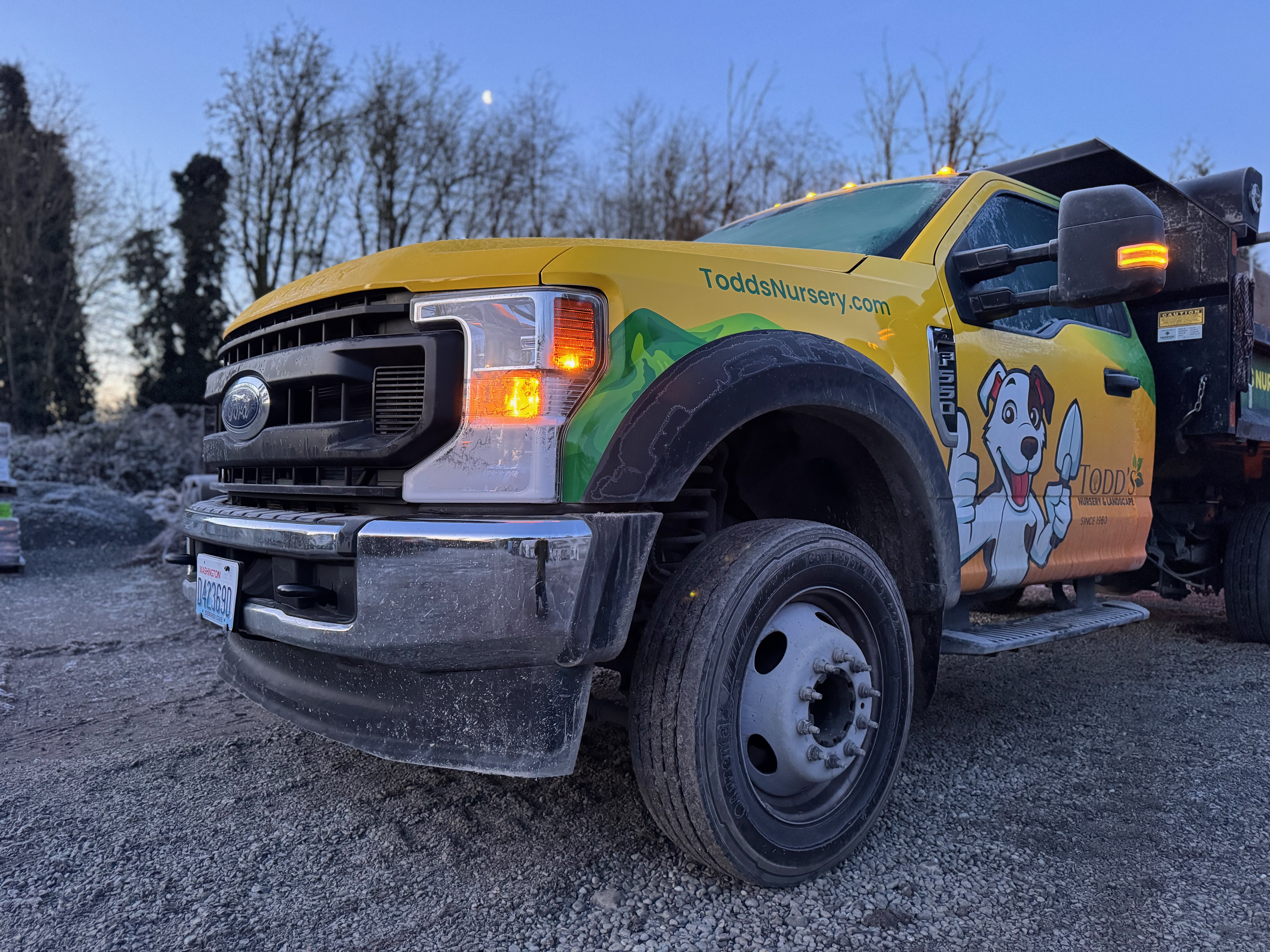 Todd's Nursery truck parked at a landscaping site in Puyallup, WA, showcasing their branding and services.