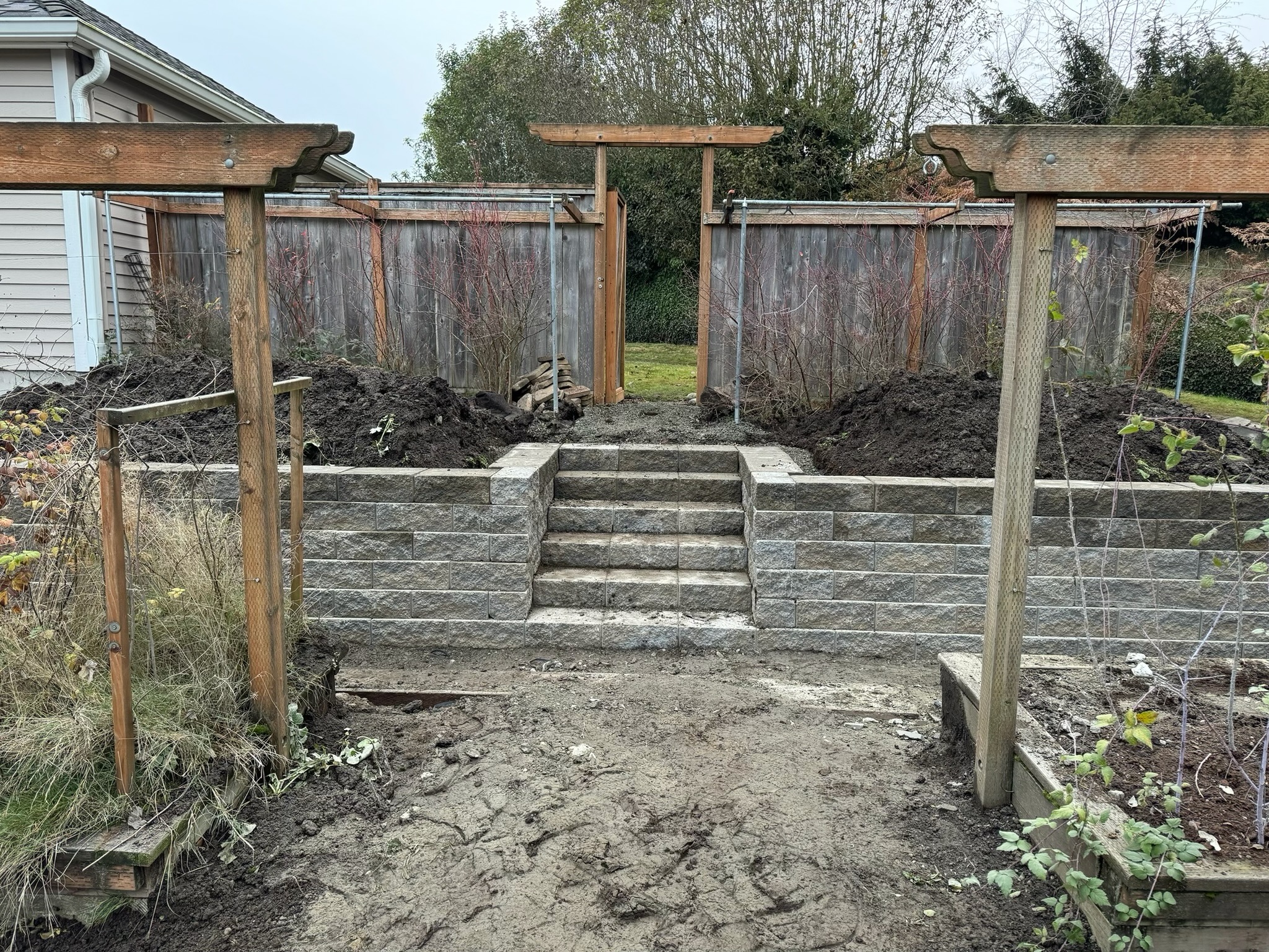 Stone retaining wall with steps and wooden arbors at Todd's Nursery, Puyallup, WA