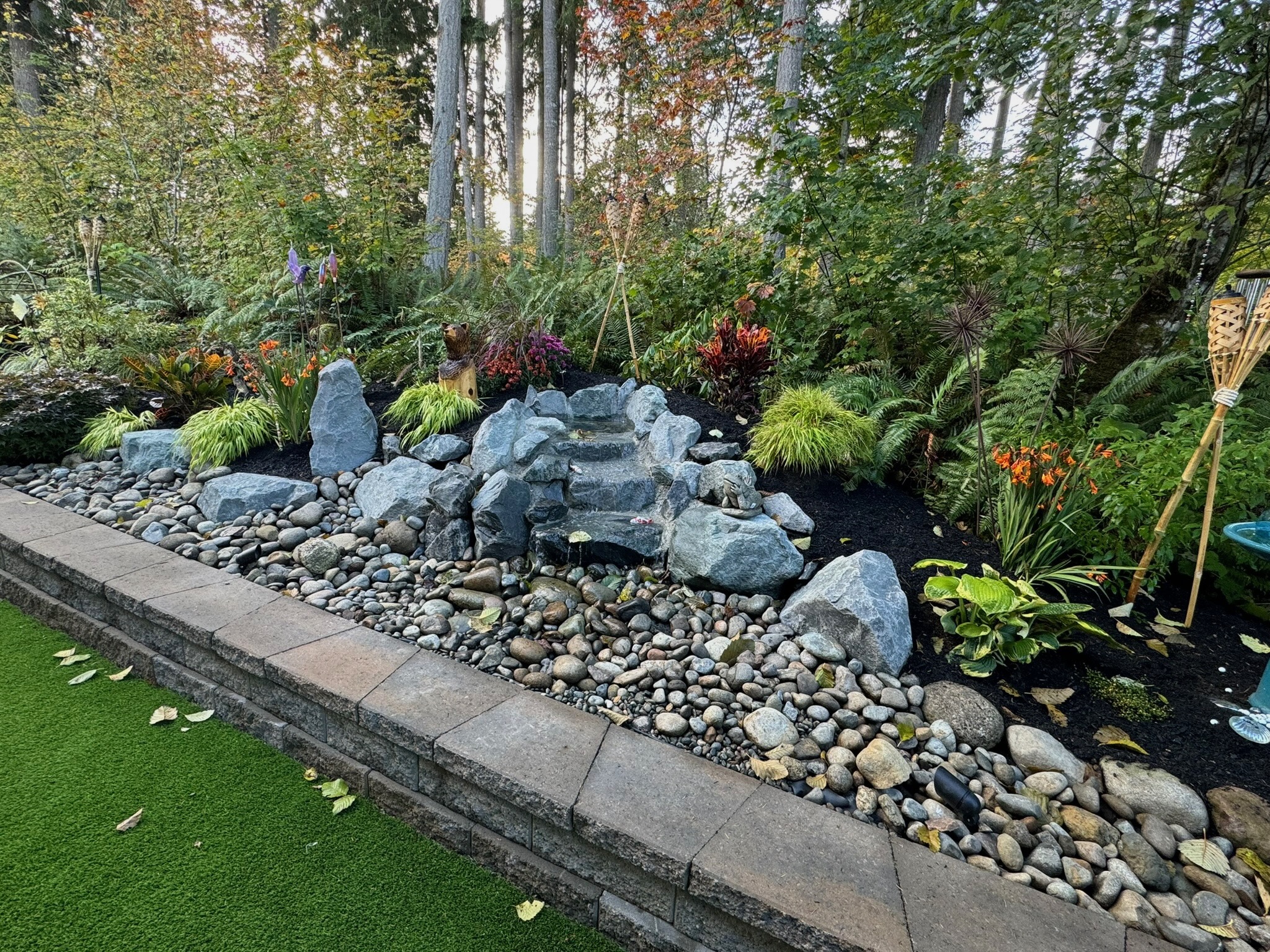 Lush garden with water feature, ferns, and rocks at Todd's Nursery in Puyallup, WA