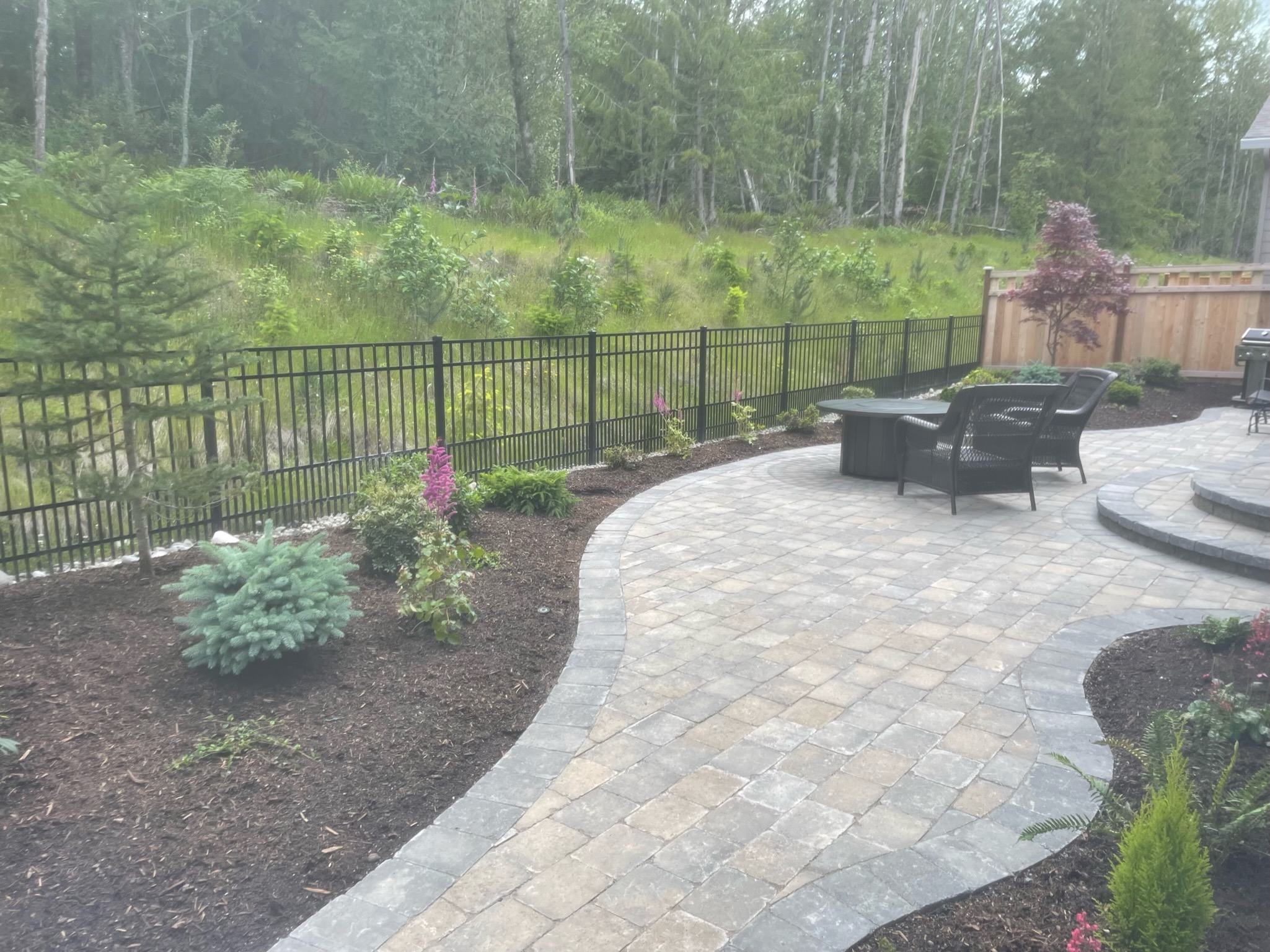 Elegant patio with pavers, diverse plantings, and seating area by Todd's Nursery in Puyallup, WA