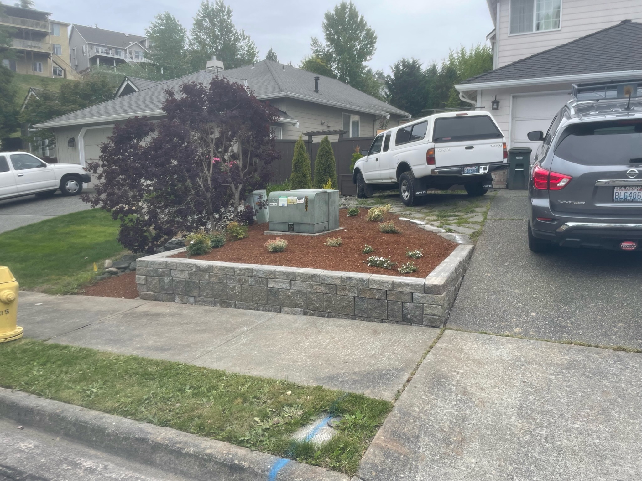 Retaining wall with mulch and shrubs by Todd's Nursery in Puyallup, WA