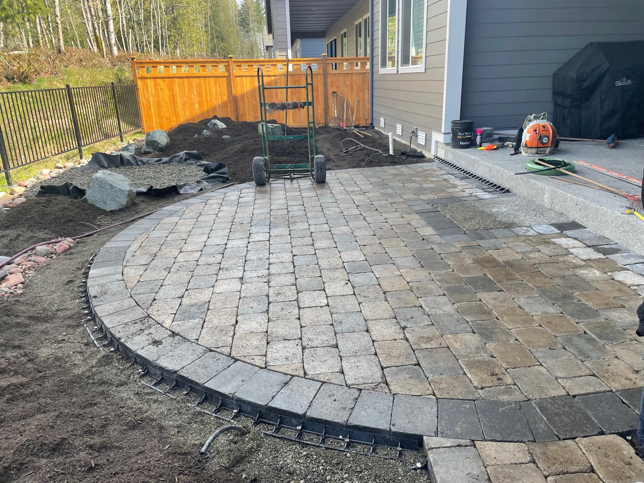 Patio with pavers and retaining wall by Todd's Nursery in Puyallup, WA, featuring landscaping elements.