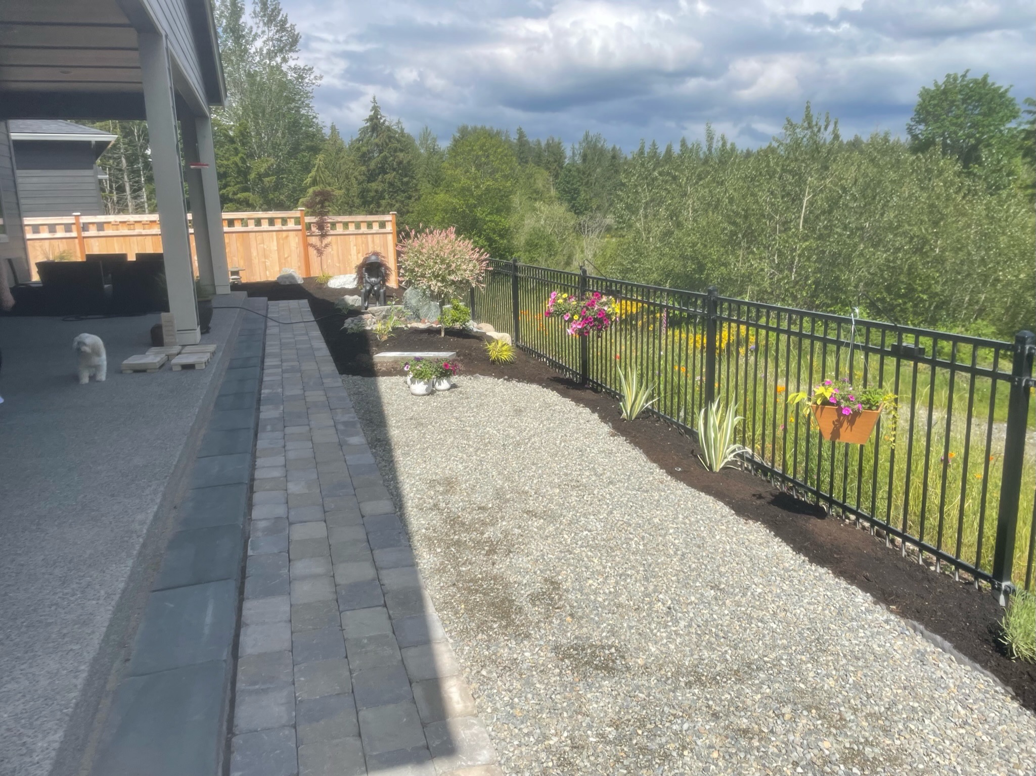 Patio with retaining wall, flowers, and fence at Todd's Nursery in Puyallup, WA.