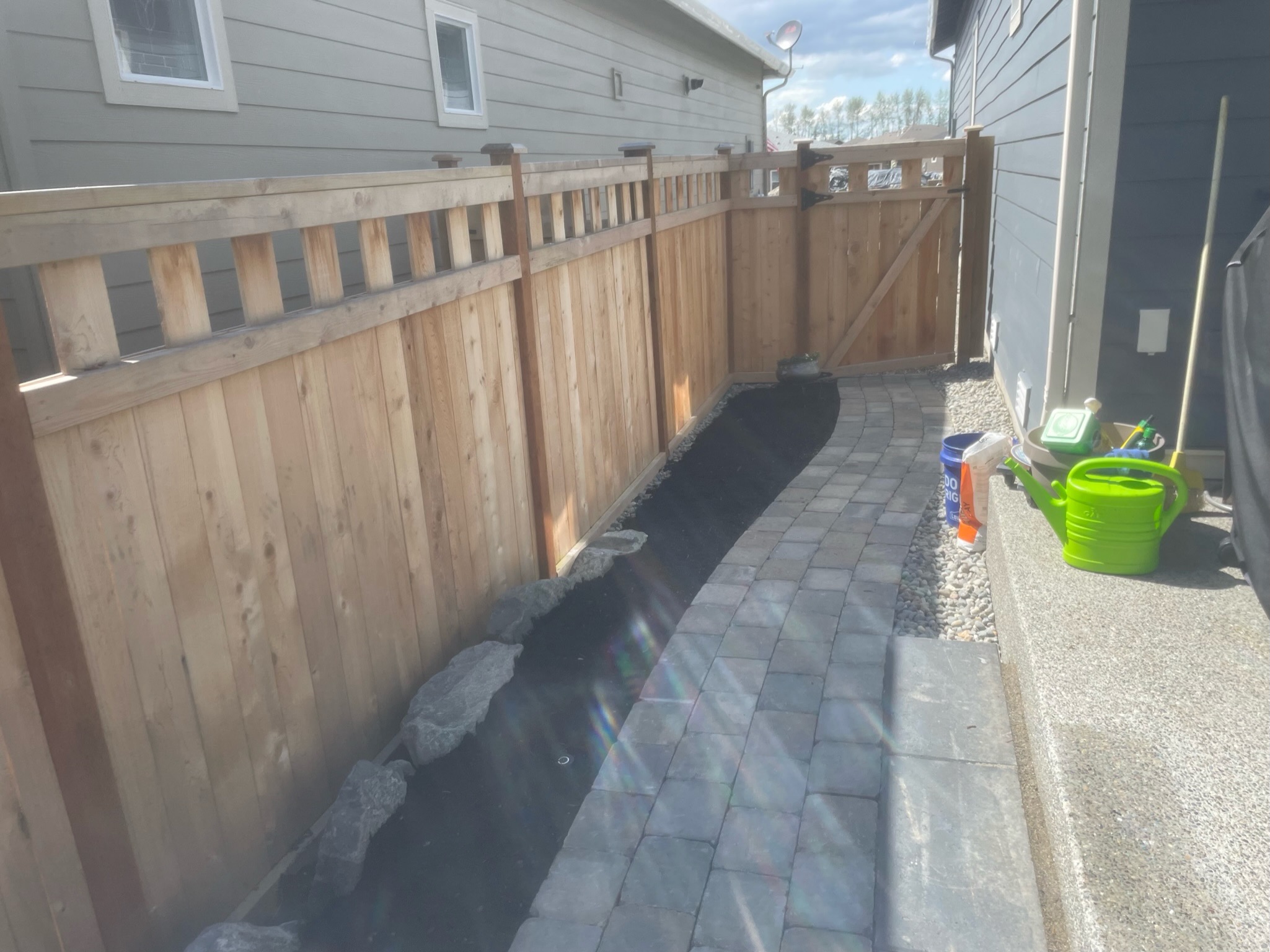 Paver pathway beside wooden fence at Todd's Nursery in Puyallup, WA
