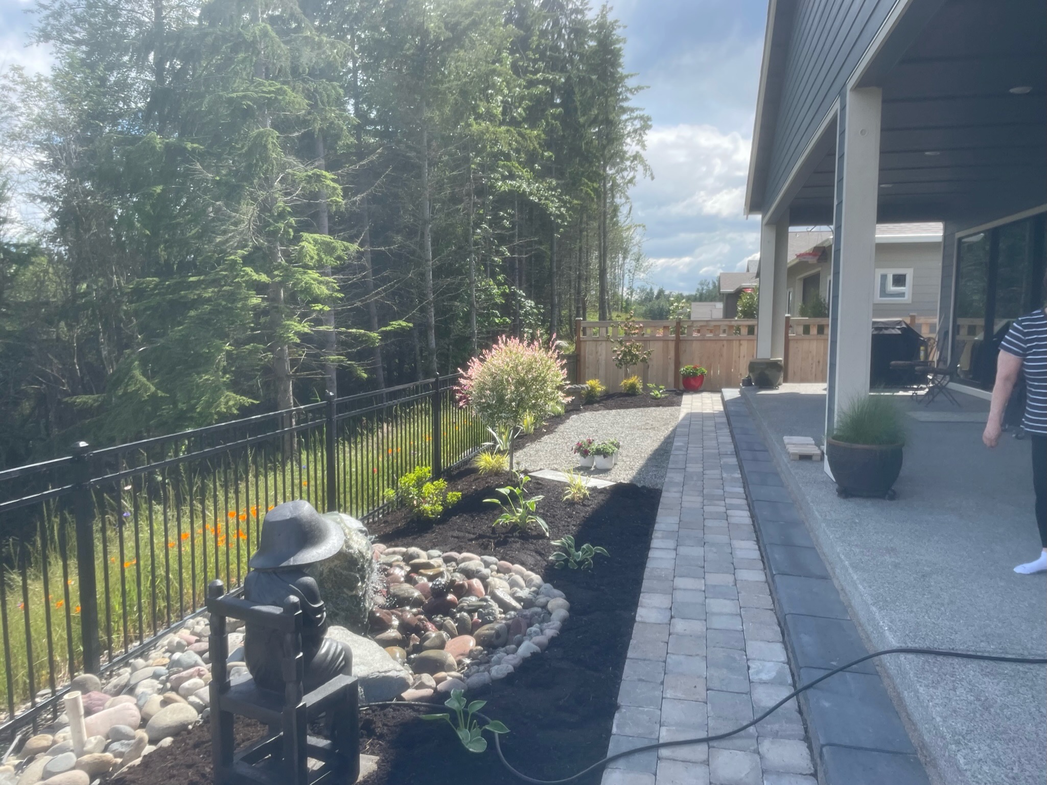 Patio with water feature, plants, and stone path by Todd's Nursery in Puyallup, WA