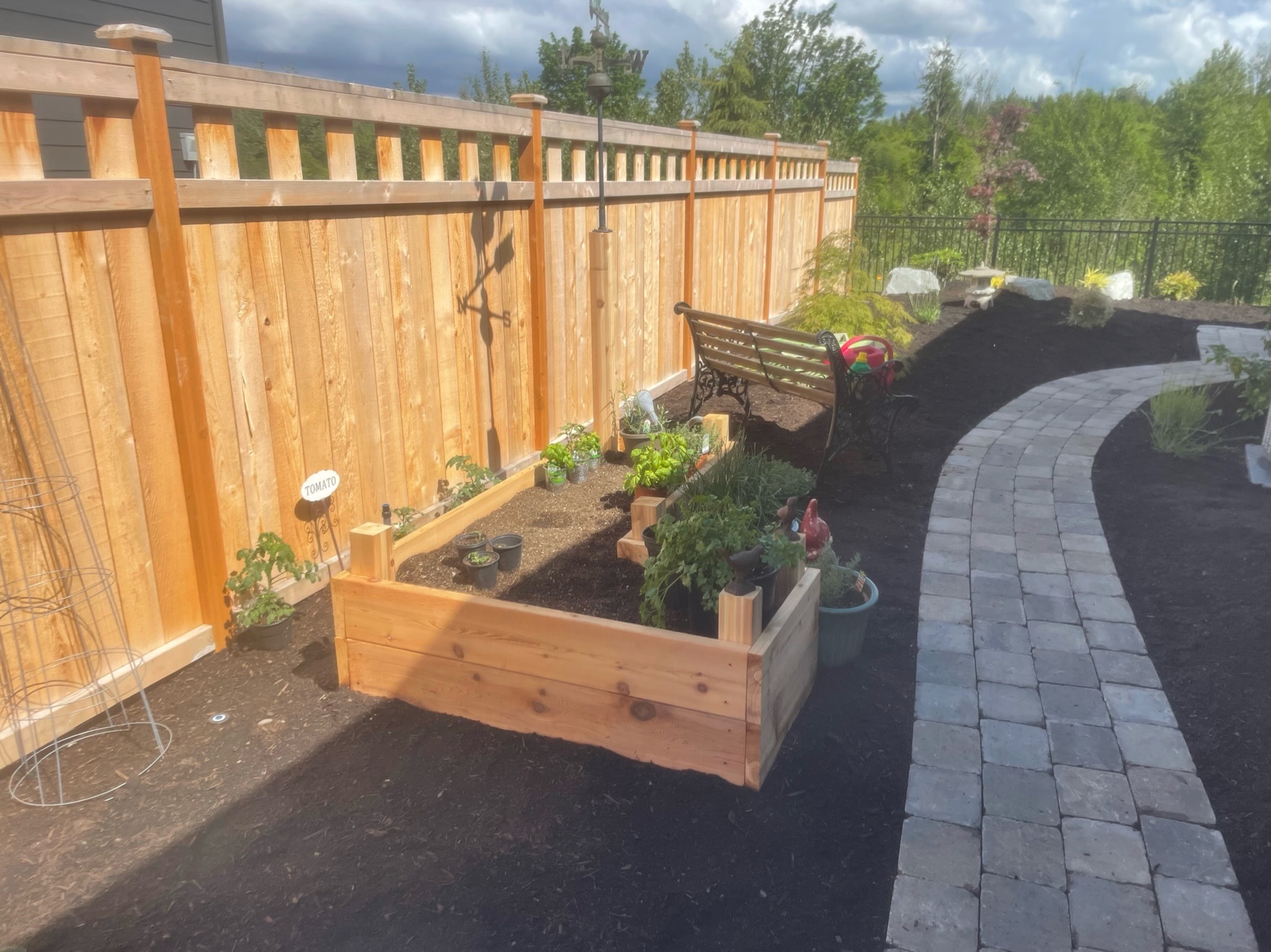Garden with raised beds, stone path, and bench at Todd's Nursery in Puyallup, WA