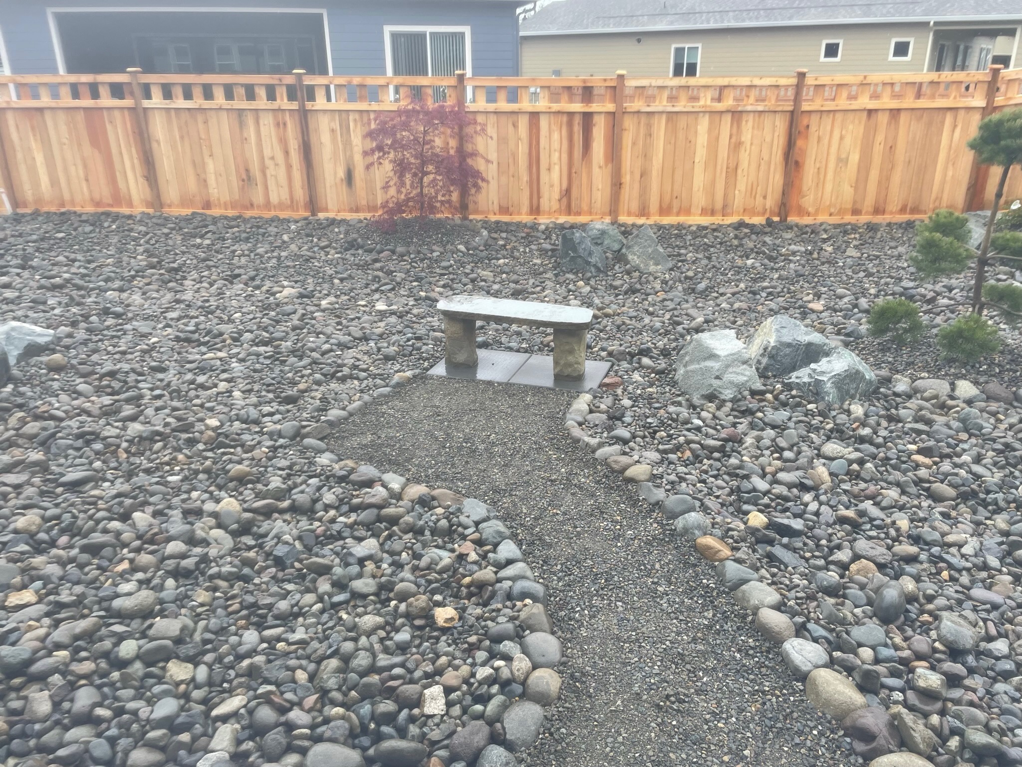 Zen garden with stone path, bench, Japanese maple, and rocks by Todd's Nursery in Puyallup, WA.