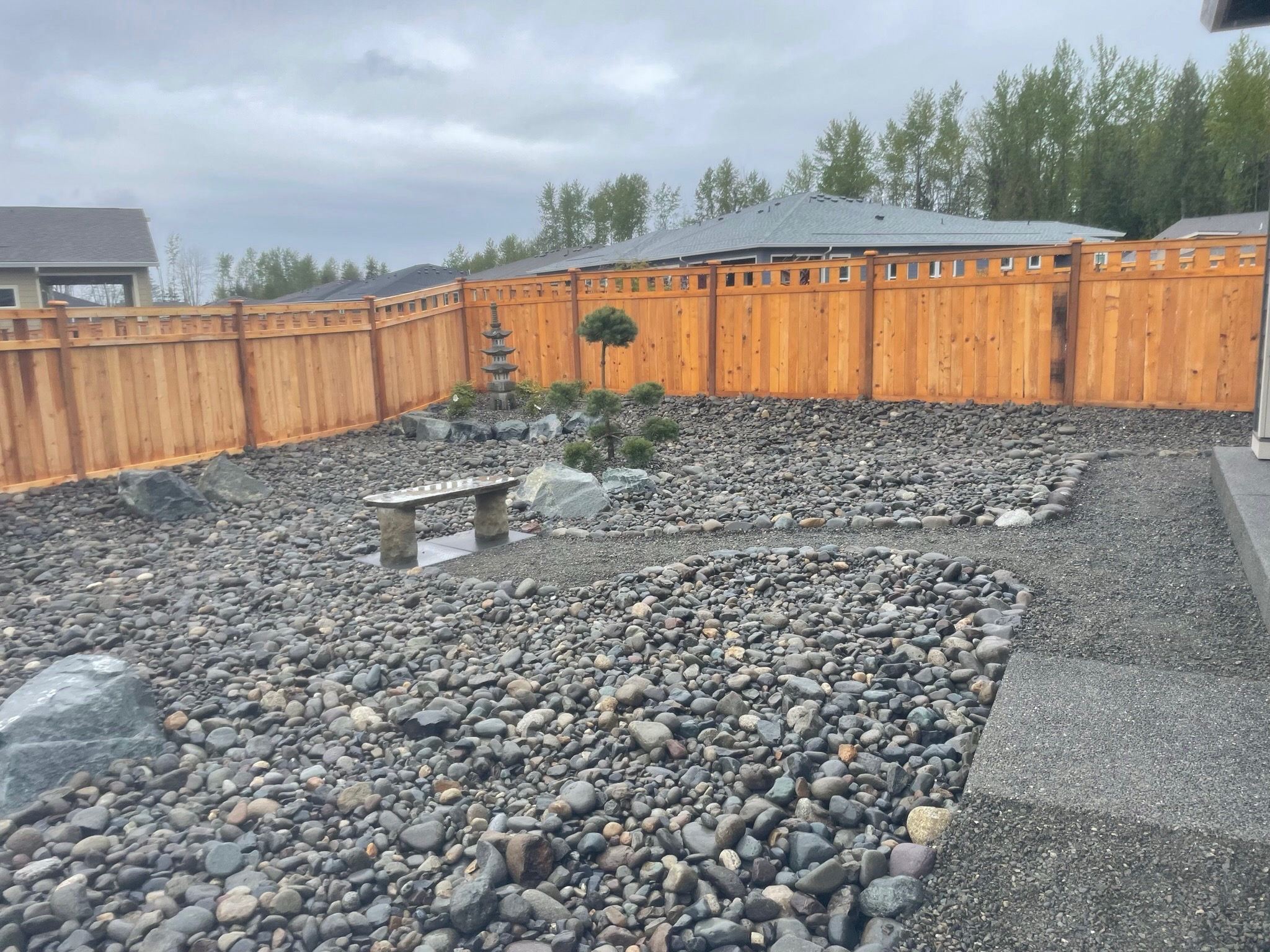 Zen garden with stone path, pagoda, and wooden fence by Todd's Nursery in Puyallup, WA.