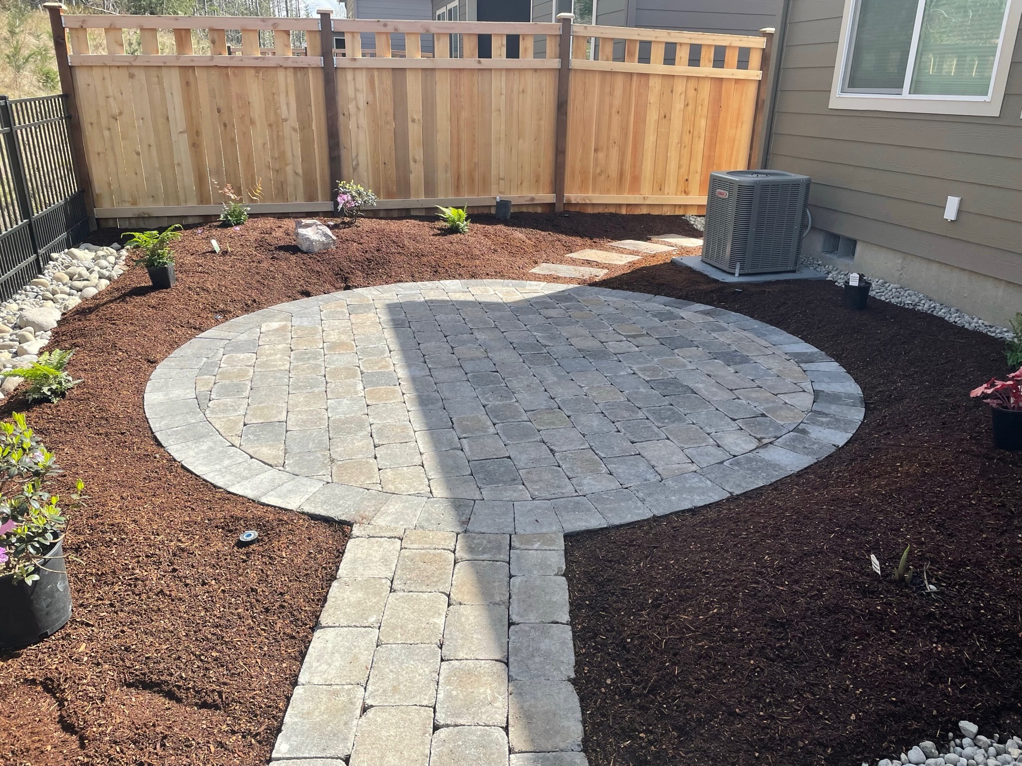 Circular stone patio with pathway, mulch, and plantings by Todd's Nursery in Puyallup, WA