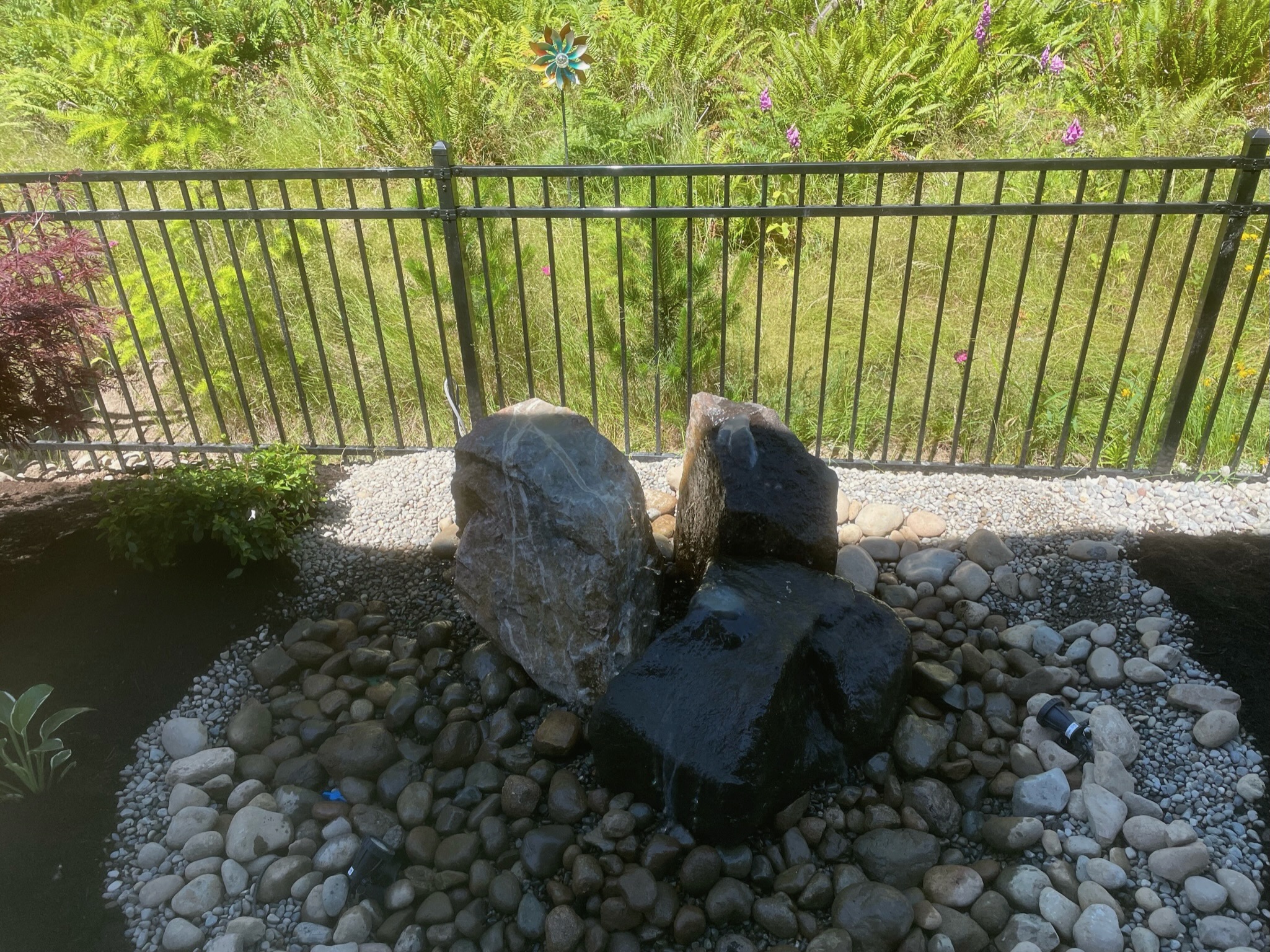 Rock water feature with pebbles and plants at Todd's Nursery in Puyallup, WA