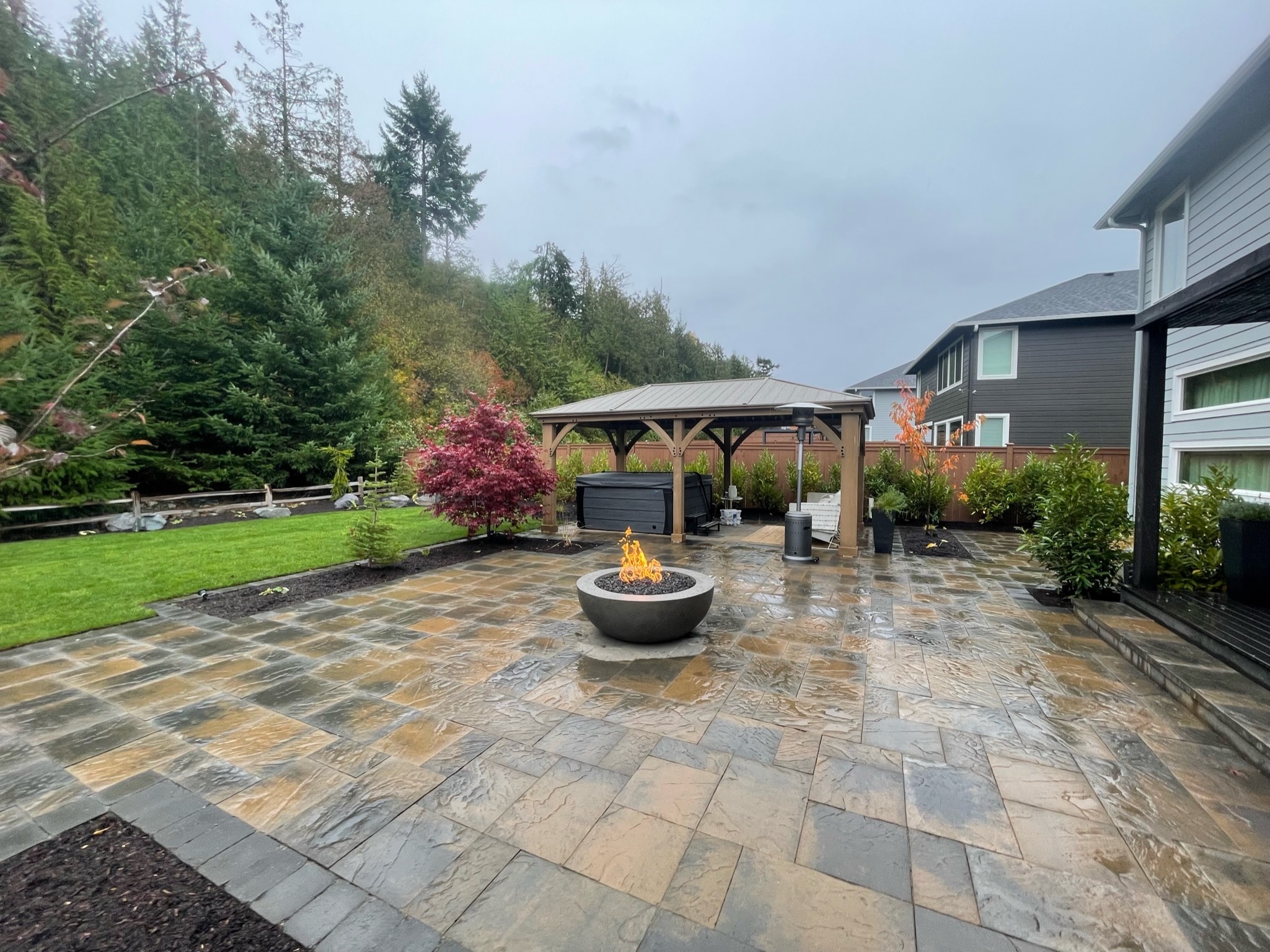 Spacious patio with fire pit, gazebo, and lush plantings by Todd's Nursery in Puyallup, WA