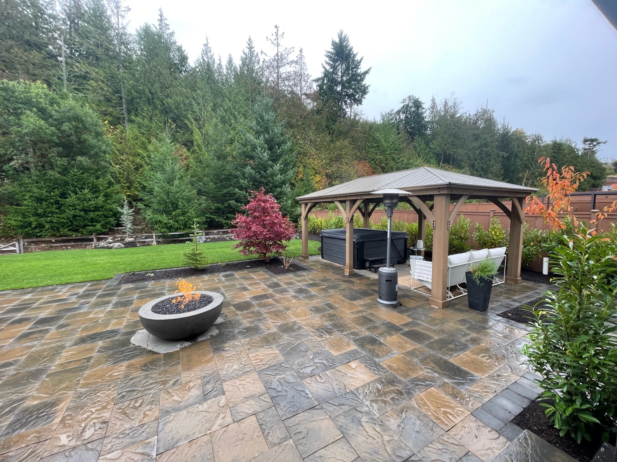 Spacious patio with fire pit, gazebo, and lush greenery by Todd's Nursery in Puyallup, WA.