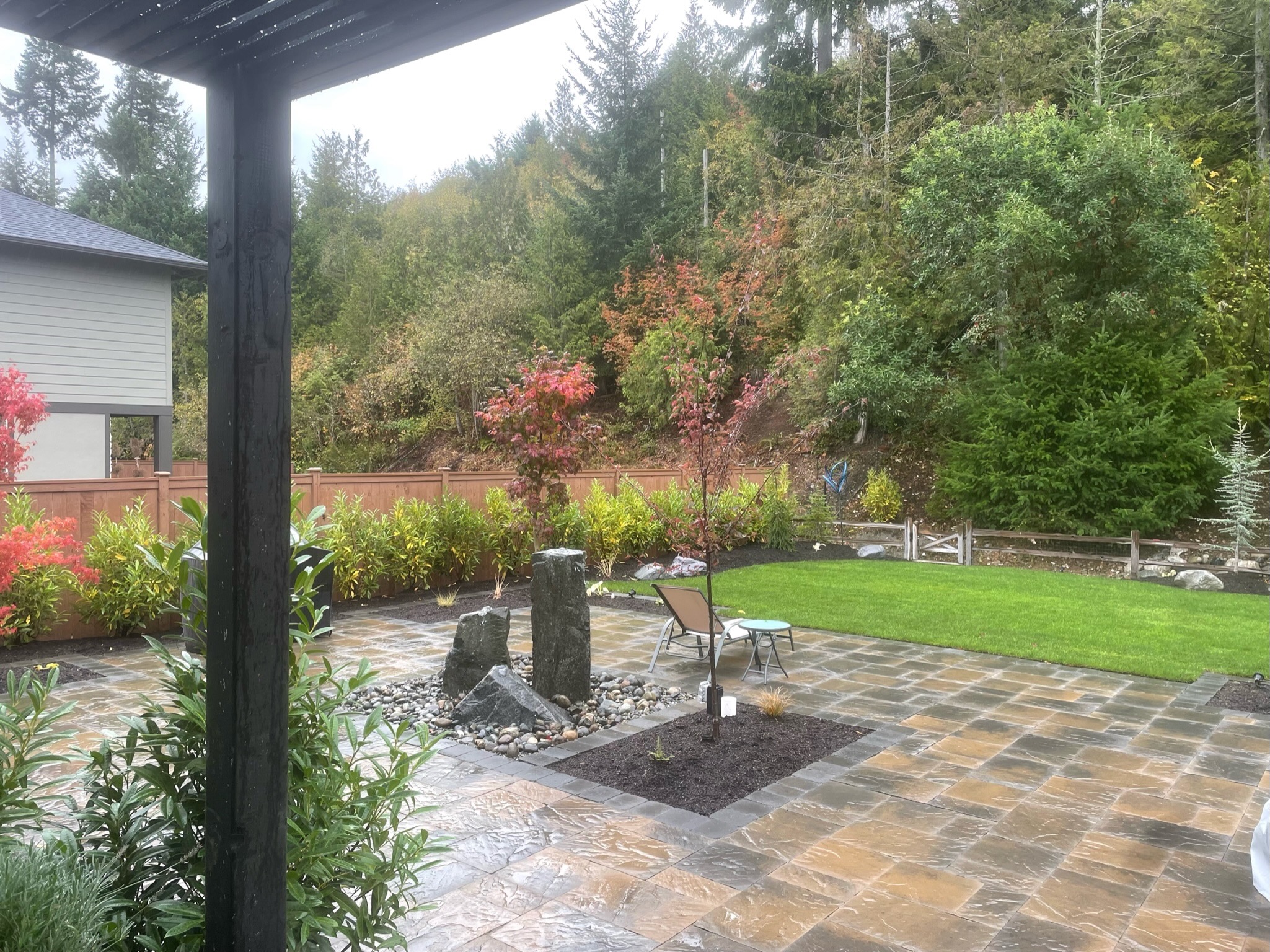 Patio with stone water feature, maples, and lawn at Todd's Nursery in Puyallup, WA