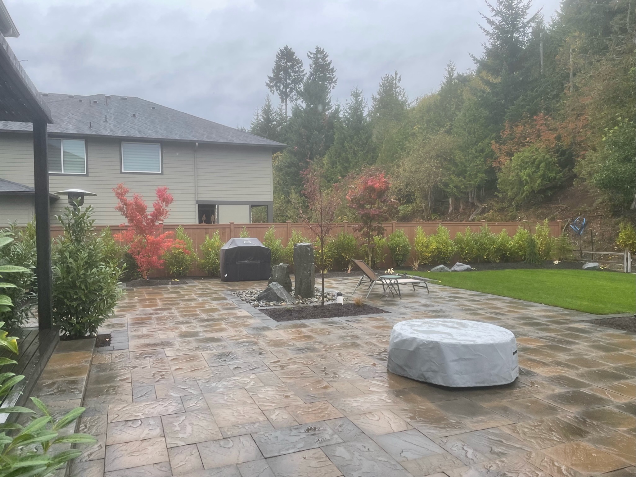 Spacious patio with water feature, Japanese maples, and lush lawn at Todd's Nursery in Puyallup, WA.