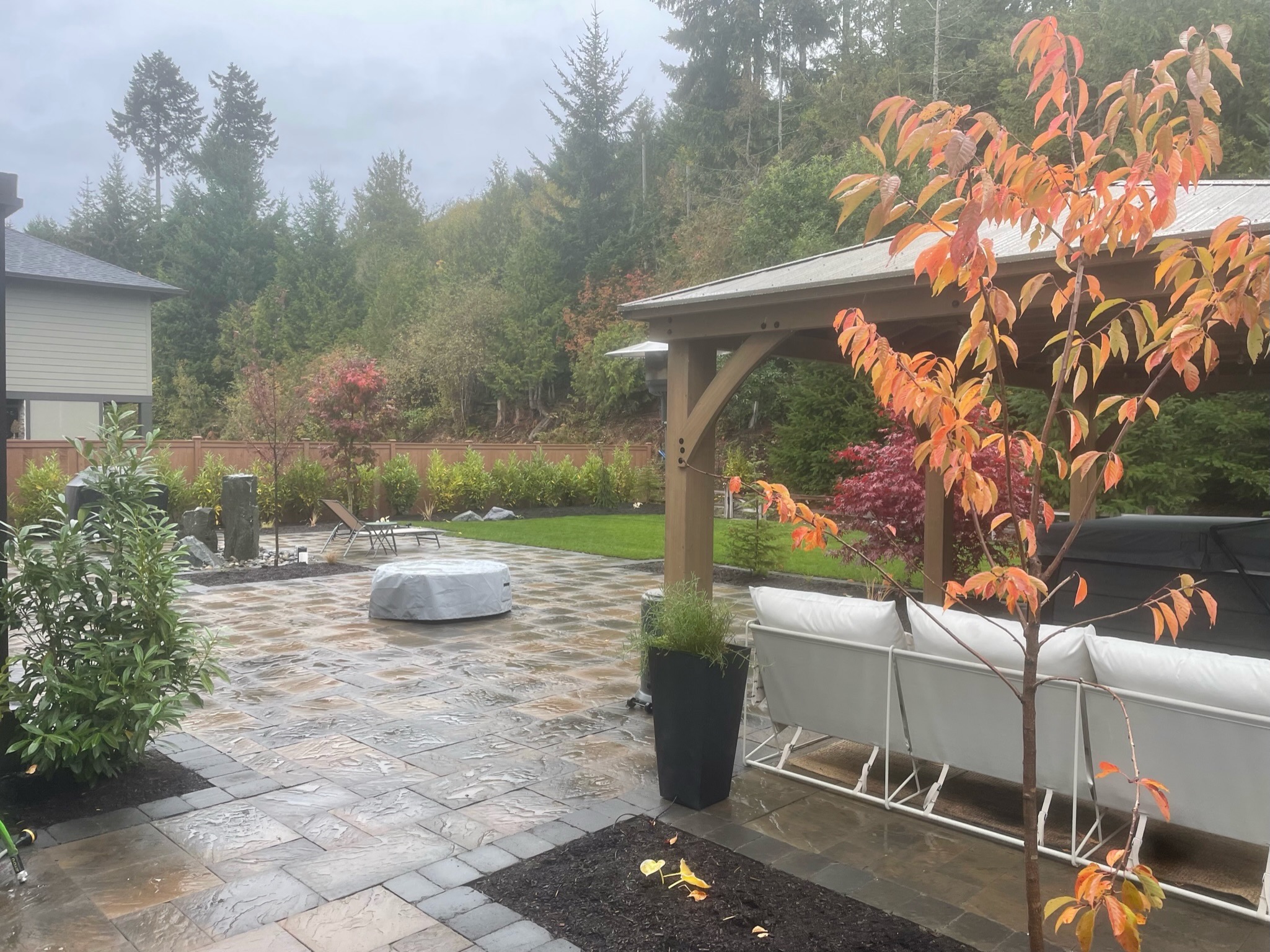 Todd's Nursery patio with pergola, water feature, and vibrant plantings in Puyallup, WA