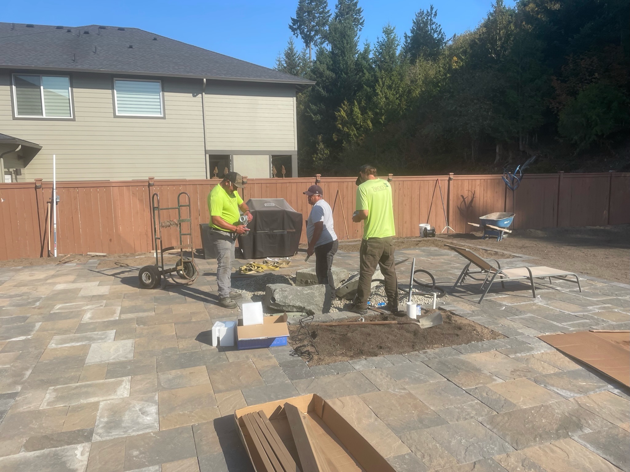 Workers installing a stone paver patio at Todd's Nursery in Puyallup, WA