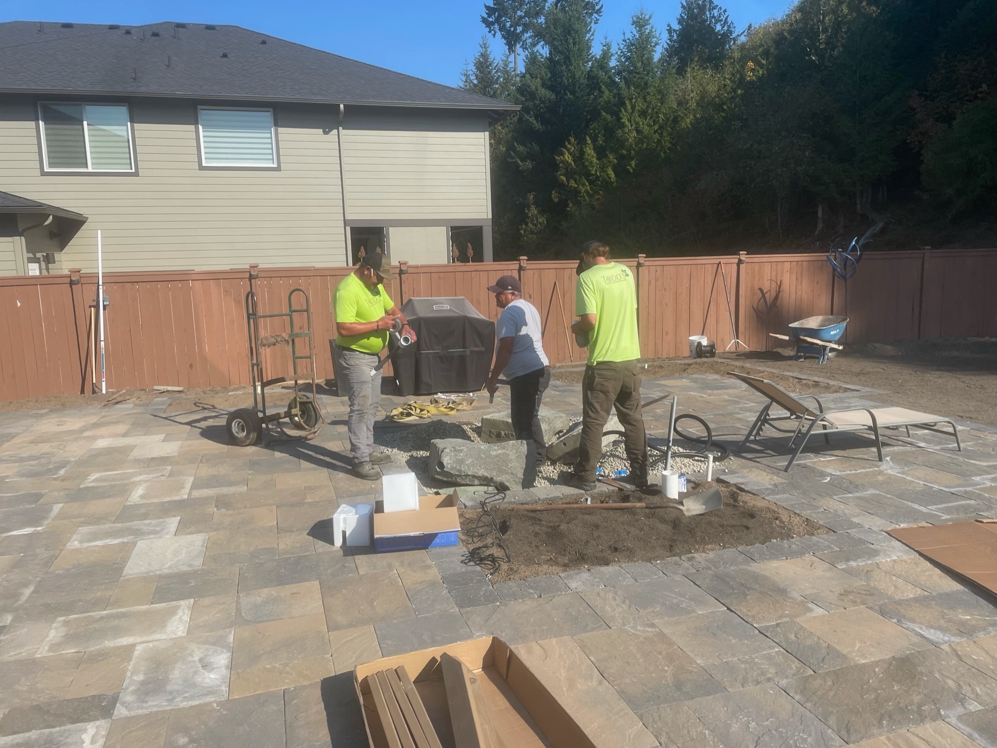 Todd's Nursery landscaping project with stone patio and workers in Puyallup, WA