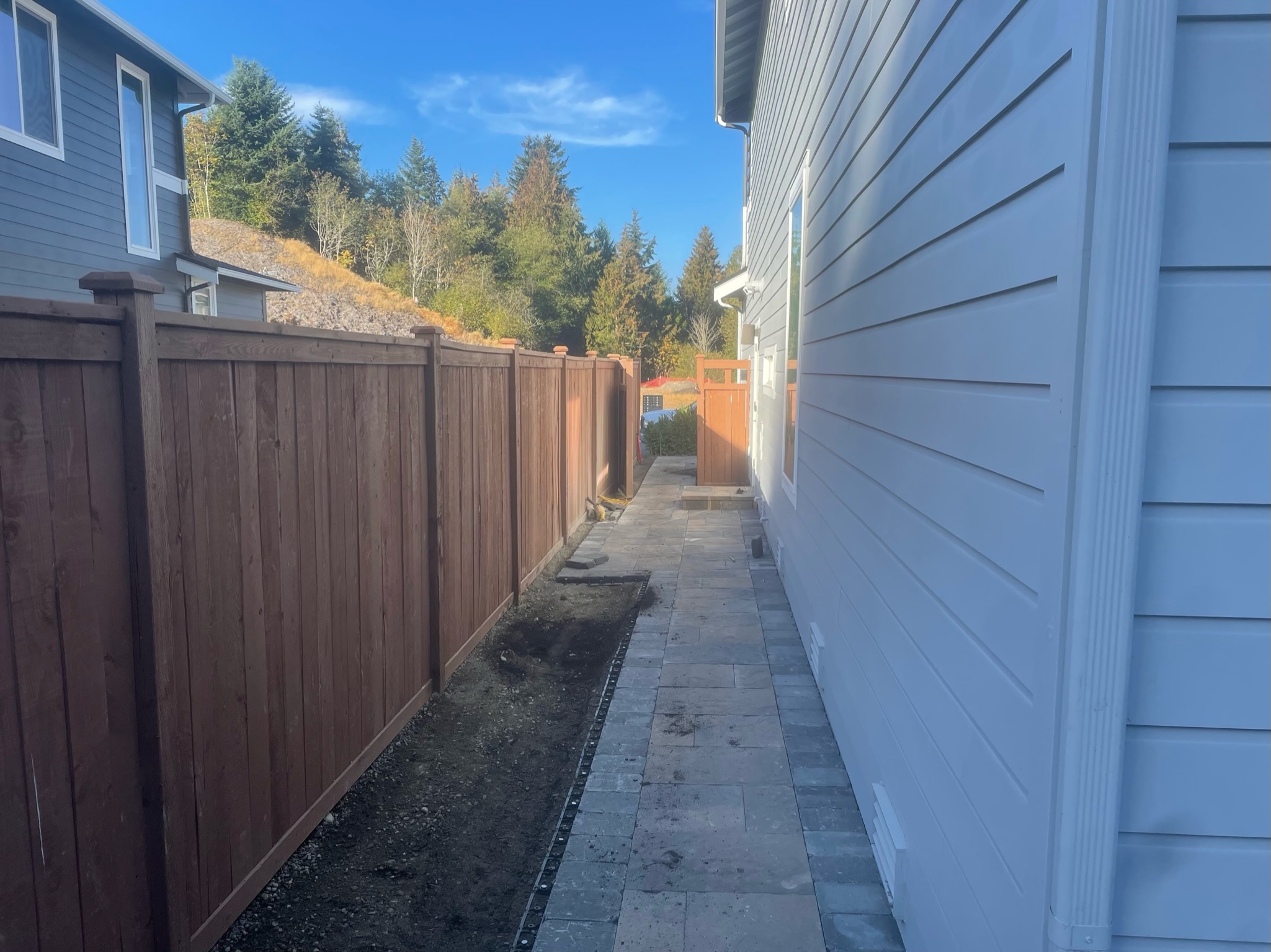 Paved sidewalk with wooden fence by Todd's Nursery in Puyallup, WA