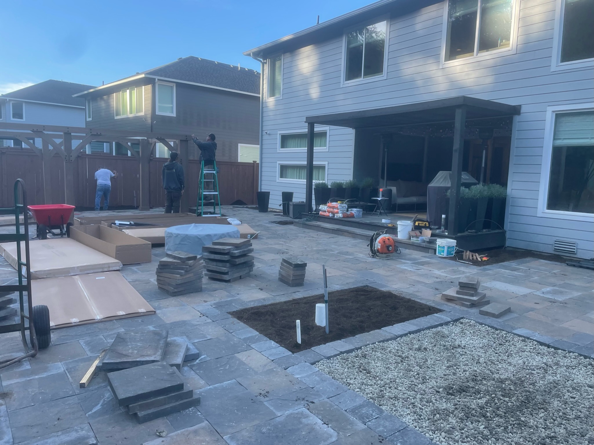 Patio construction with pergola, paving stones, and workers at Todd's Nursery in Puyallup, WA