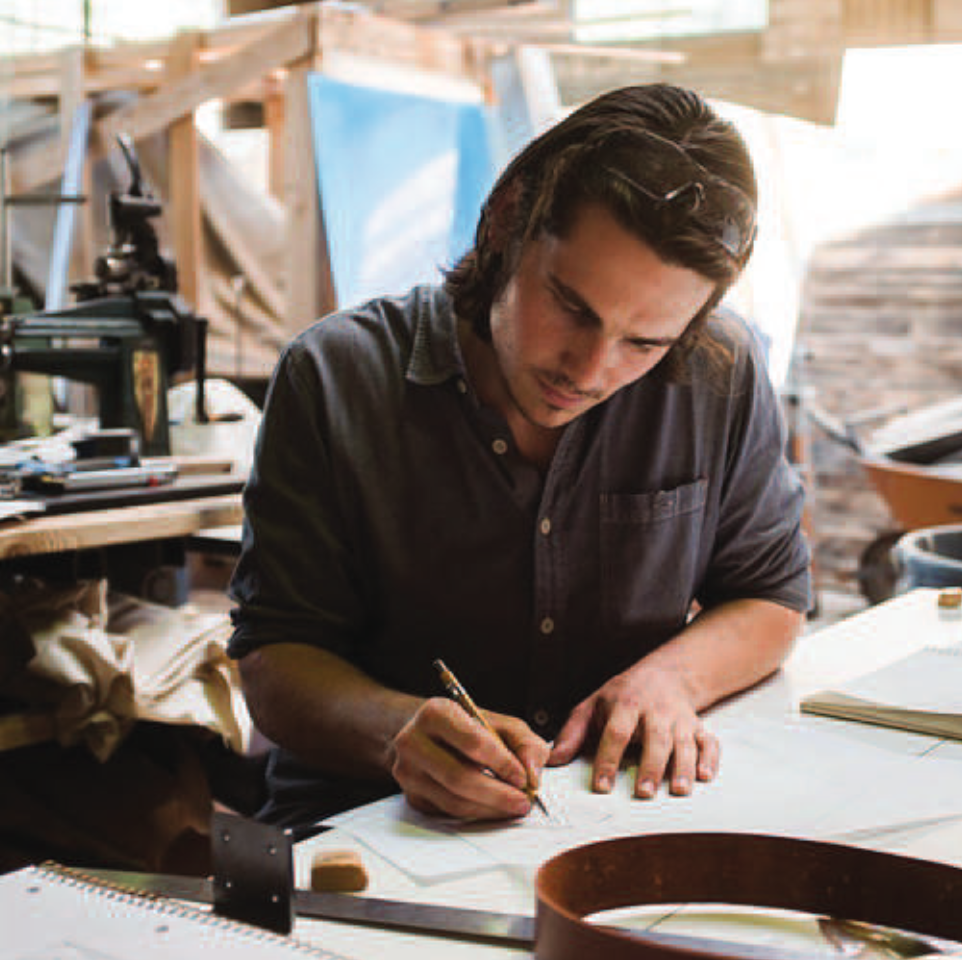 handsome brown haired engineer drawing at table in warehouse