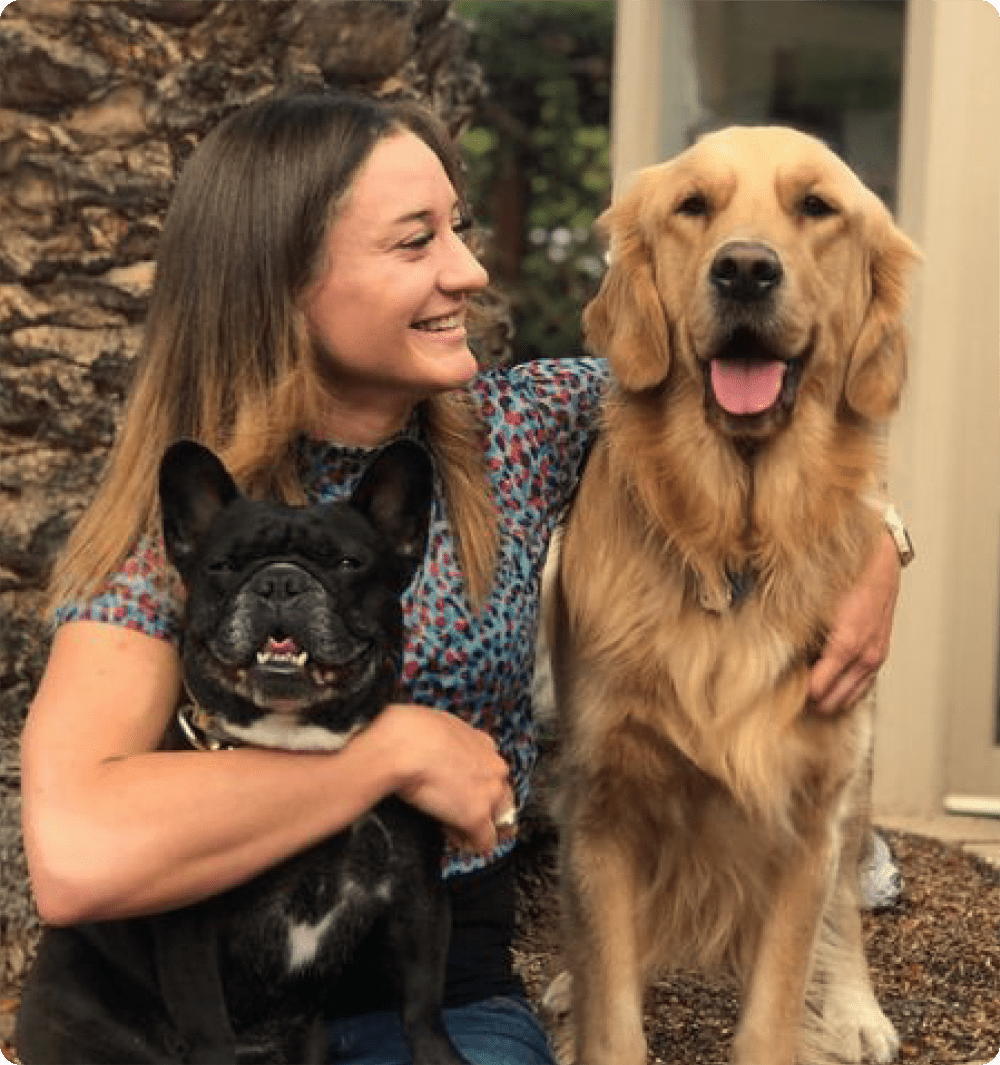 A veterinarian smiling with two dogs