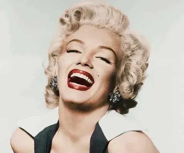 Marilyn Monroe sorrindo com os seus belos cabelos curtos loiros