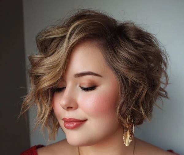 Mulher com cabelo curto em corte bob ondulado e iluminado, ideal para valorizar rostos redondos.