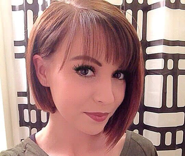 Mulher com cabelo curto em corte chanel clássico e franjinha leve na testa.